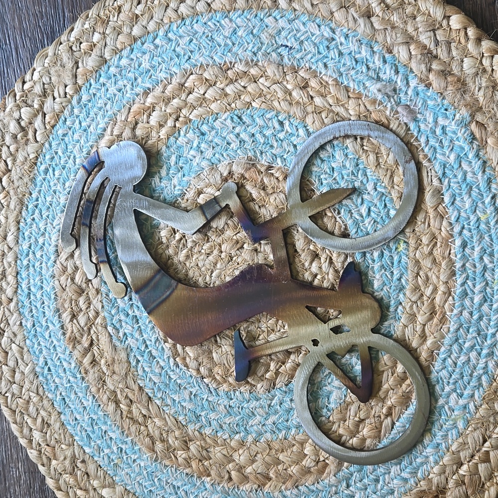 Metal kokepelli on a bicycle. Has metal hanger